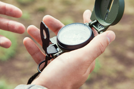 Man with compass in hand outdoor. Travel concept.