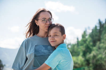 A child embraces mom in the mountain tripの写真素材