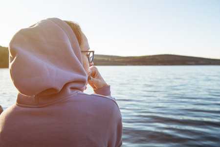 Young beautiful woman sitting on the pier