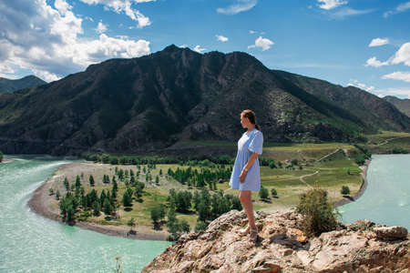 Woman in blue dress on the confluence of two rivers Katun and Chuyaの写真素材