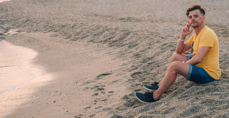 Man sits on the beach and looks at the sea in Alanya cityの写真素材