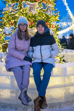 Happy woman wirh her son posing in festive New Year eve street.の写真素材