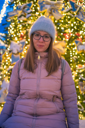 Happy woman posing in festive New Year eve street.の写真素材