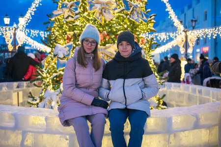 Happy woman wirh her son posing in festive New Year eve street.の写真素材