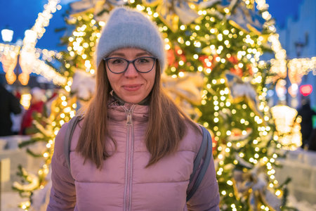 Happy woman posing in festive New Year eve street.の写真素材