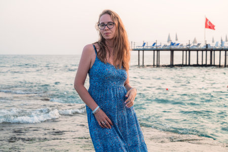 Woman sits on the beach and looks at the sea in Alanya cityの写真素材