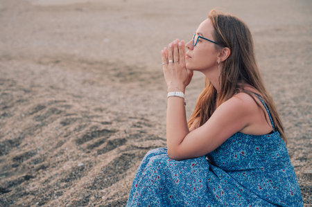 Woman sits on the beach and looks at the sea in Alanya cityの写真素材