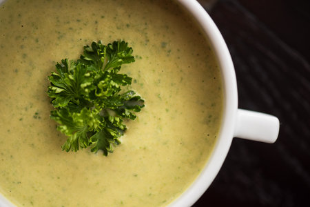 Cream cheese soup with parley in bowl, top view, closeup photo. Healthy food concept.の写真素材