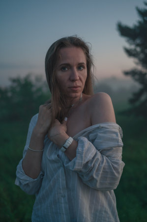 Woman in a field with misty fogの写真素材
