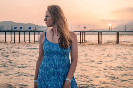 Woman sits on the beach and looks at the sea in Alanya cityの写真素材