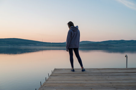 Woman on the pier at lake, closeup portrait, summer sunsetの写真素材