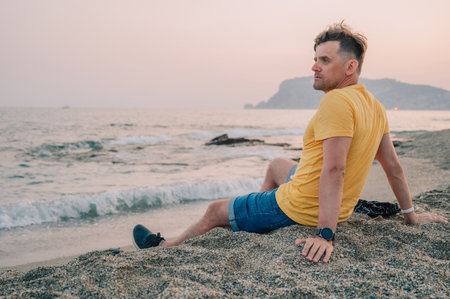 Man sits on the beach and looks at the sea in Alanya city, Turkey. Traveling or vacation conceptの写真素材