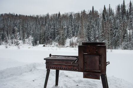 Winter patio of the guest house. Barbecue or brazier outdoor in winter near the house.の写真素材