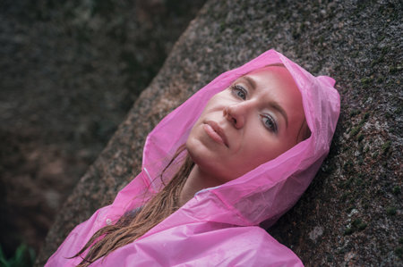 Portrait of woman in the raincoat the taiga forest and rocks of the Stolby nature reserve park,...