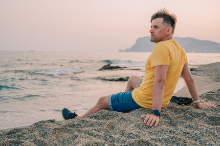 Man sits on the beach and looks at the sea in Alanya city, Turkey. Traveling or vacation conceptの写真素材