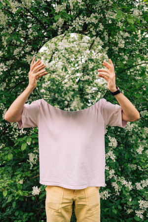 Creative male portrait with mirror in a blooming apples spring gardenの写真素材