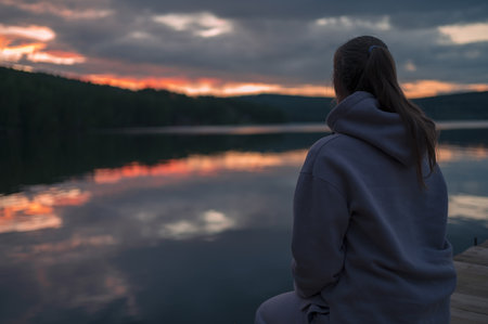 Woman sitting on the pier, closeup portrait, beauty summer sunsetの写真素材