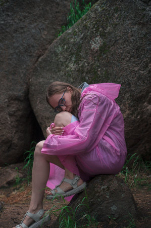 Woman in the raincoat the taiga forest and rocks of the Stolby nature reserve park, Krasnoyarsk, Russiaの写真素材