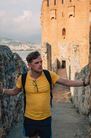 Man at fortress ruins of the historical Red Tower - Kizil Kule, in Alanya Castle, the famous touristic place.の写真素材