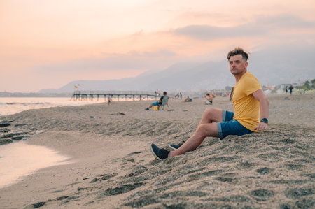 Man sits on the beach and looks at the sea in Alanya city, Turkey. Traveling or vacation concept
