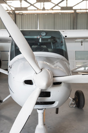 Small private lightweight propeller airplane in hangar, closeup photo