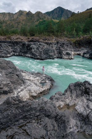 Woman at the river Katun at summer day. Trip on Altai Mountains in Altai Republic