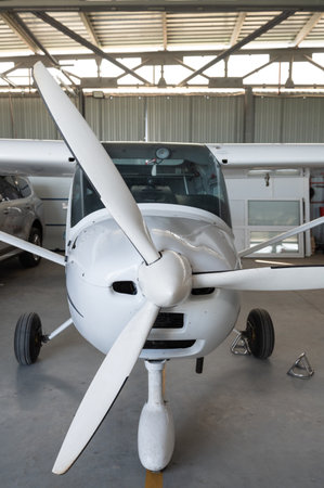 Small private lightweight propeller airplane in hangar, closeup photo