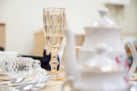 Patterned crystal glass and white teapot on a tableの写真素材