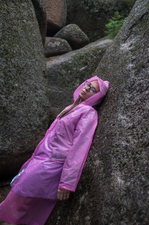 Portrait of woman in the raincoat the taiga forest and rocks of the Stolby nature reserve park, Krasnoyarsk, Russiaの写真素材