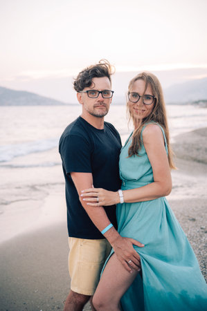 A smiling couple shares a joyful moment on the beach at sunset, the man and the woman near the sea waves, Alanya, Turkeyの写真素材