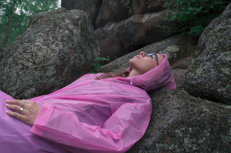 Woman in the raincoat the taiga forest and rocks of the Stolby nature reserve park, Krasnoyarsk, Russiaの写真素材