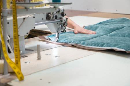 Tailor stitching furniture upholstery elements with the sewing machine. Furniture productionの写真素材