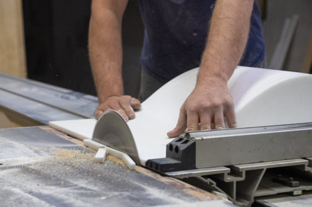 The craftsman cuts and adjusts the size of the acrylic sink with a circular sawの写真素材