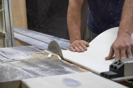 The craftsman cuts and adjusts the size of the acrylic sink with a circular sawの写真素材