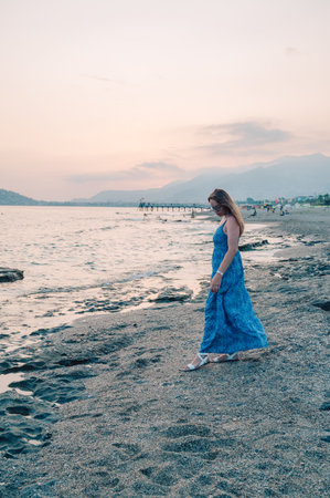Woman sits on the beach and looks at the sea. Travelling or vacation conceptの写真素材