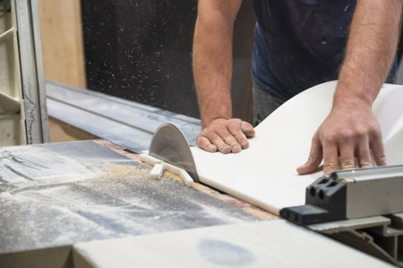 The craftsman cuts and adjusts the size of the acrylic sink with a circular saw
