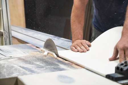 The craftsman cuts and adjusts the size of the acrylic sink with a circular sawの写真素材