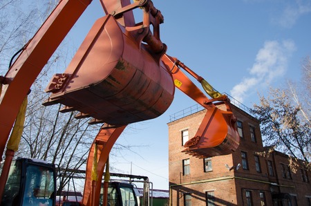 Orange excavator bucket on sky backgoundの写真素材