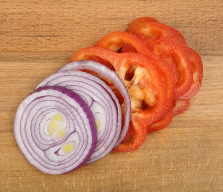 sliced onion and pepper on a wooden boardの写真素材