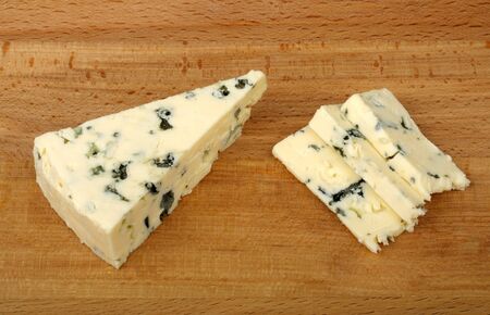 ??sliced blue cheese on a wooden cutting board