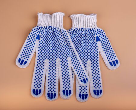 Cotton work gloves on sandy orange background