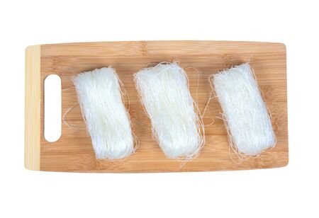 Dry bean noodles on a cutting board isolated on white.の写真素材