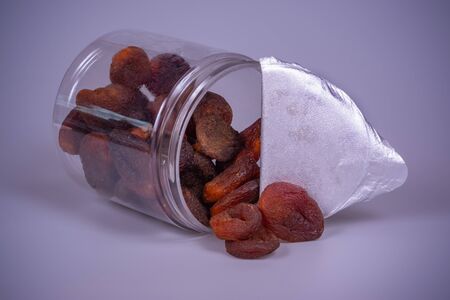 Dry apricot in a plastic jar on a gray backgroundの写真素材