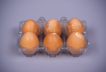 Guinea fowl eggs in plastic packaging on a gray backgroundの写真素材