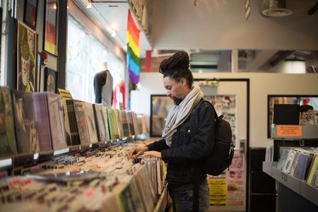 man with dreadlocks searching through vinyl recordsのeditorial素材