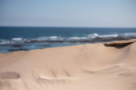 Sand dune at local beach with ocean in the backgroundの写真素材