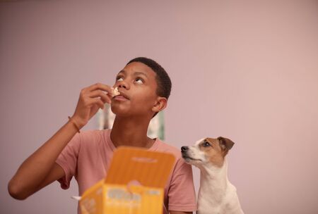 Close up portrait of young boy watching television with his petの写真素材