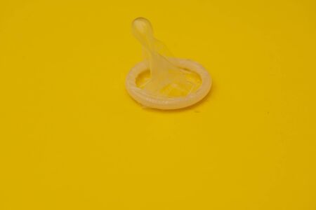 Condom isolated against yellow backgroundの写真素材