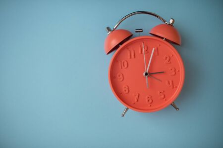 Clock isolated against solid background with copy space