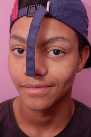 Vertical portrait of teenager with cap turned on backwards